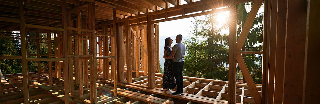 A couple standing in a house under construction 